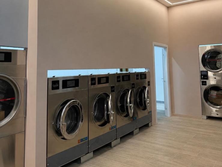 La sala di una lavanderia professionale a Focene, con le lavatrici alimentate